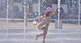 Una niña juega en unas fuentes para aliviar el calor del verano.