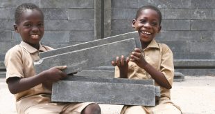 Niños felices porque su nueva aula de clase está siendo construida con ladrillos de plástico en Côte d'Ivoire.