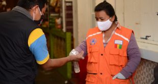 Una mujer aplica desinfectante de manos a un cliente a la entrada de un mercado municipal en la ciudad guatemalteca de San Marcos.