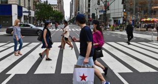 Gente con mascarilla cruzando por un paso de cebra de una calle de Nueva York