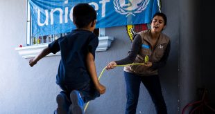 Un niño en un centro de Tijuana en México juega con una trabajadora de UNICEF.