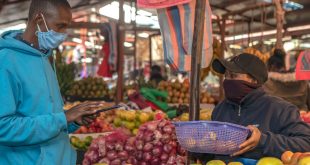 Un joven compra fruta en un mercado de Kenya.