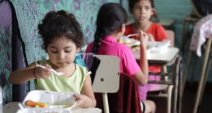 Estas niñas salvadoreñas eran beneficiarias de los almuerzos escolares. Ahora esas raciones de alimentos se preparan para que los niños se los lleven a sus casas.